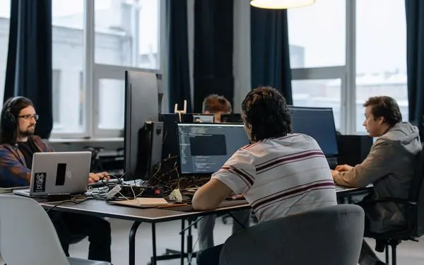 Profissionais trabalhando em computadores num escritório aberto